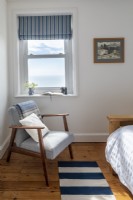 Mid century modern armchair with sea view in bedroom
