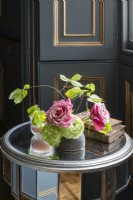 Old roses, beech leaves, and hydrangea in vase in panelled bedroom