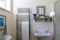 Simple vintage style bathroom, with modern chrome towel rail.