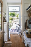 View to front door, with bicycle in hallway, and rustic vintage ornaments