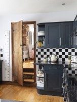 Black and white sunken kitchen with wooden flooring and door
