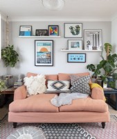 Display of artwork above salmon pink sofa in modern living room
