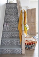 Staircase with decorative mosaic tiling on steps in modern hallway