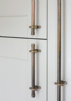 Detail of salvaged pipe door handles on kitchen cabinets