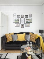 Black sofa and display of framed pictures in modern living room