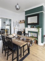 Modern dining room with green painted chimney breast 