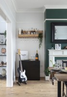 Small bar area and electric guitar in dining area of through lounge