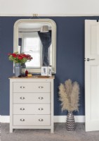 Small chest of drawers and mirror in bedroom