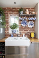Double sink in modern kitchen with exposed brickwork walls