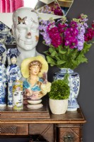 Colourful flower arrangement in blue and white vase with ornaments
