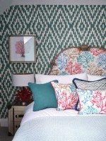 Colourful coastal inspired bedroom with upholstered headboard and wallpaper