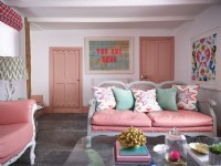 Pink upholstered sofa with artwork