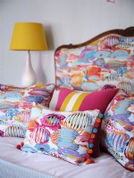 Colourful coastal cushions on bed