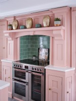 handmade kitchen with painted pink units with stainless steel cooker
