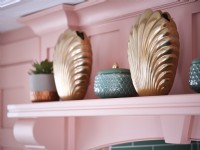 Gold clam shell ornaments on pink shelf