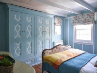 Light blue coastal themed bedroom with vintage upholstered bed