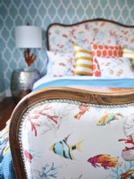 Colourful coastal themed upholstery on vintage bed