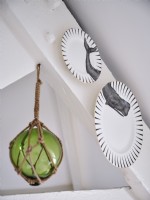 Decorative coastal themed plates and a green glass hanging ornament