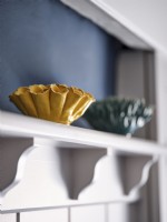 Yellow coral inspired ornament on shelf above panelled wall