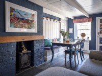 Vintage dining set next to a built in fireplace in a blue brick wall