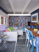 Colourful open plan dining room with patterned feature wall and marine artwork