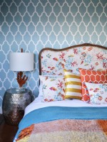Colourful upholstered bed next to coral sculptured lamp