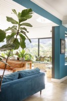 Living area with leather and velvet sofas and plants