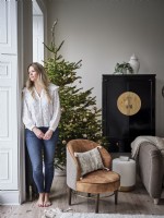 Homeowner in Christmas setting with Christmas tree and chair