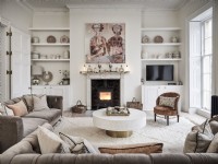 Neutral living room featuring seating, fireplace, coffee table, shelving and wall art