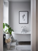 View from doorway to neutral toned en suite bathroom with house plants