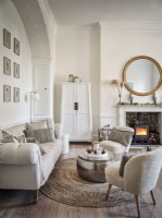 Neutral living room featuring seating, fireplace, mirror and white cabinet