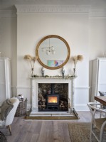 Wood burning stove, decorative mantel and circular mirror