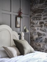 Country bedroom featuring exposed stonework and grey panels