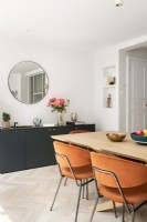 Modern dining room with mid-century velvet orange chairs 