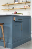 View of blue kitchen island island and open shelves