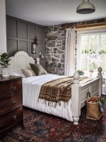 Country bedroom featuring stone wall