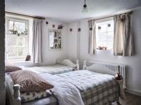 Country bedroom featuring two beds and hanging decorations