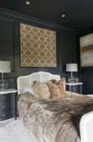 Modern black and gold bedroom with rattan bed frame