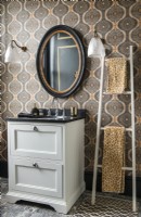 Sink unit in modern classic bathroom with patterned wallpaper