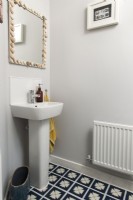 Small sink and shell framed mirror in bathroom
