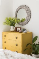 Yellow painted chest of drawers in country bedroom