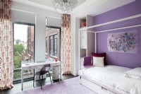 Girls bedroom in purple and white with city view.
