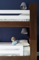 Details of brown and white wooden bunk beds, lighting and stuffed animal toy.