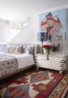 Bedroom with geometric rug and contemporary art