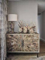 Brown cabinet with dried flower arrangement and rustic lamp