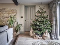 Neutral living room featuring exposed brickwork and Christmas tree with gifts 