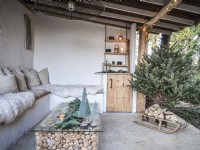 Outdoor space featuring Christmas decor and stacked logs under the coffee table