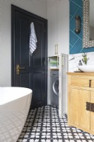 Detail of clever storage space and hidden washing machine in striking contemporary bathroom