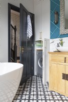 Detail of clever storage space and hidden washing machine in striking contemporary bathroom