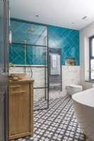 Contemporary bathroom with freestanding bath, shower, wall hung toilet bold tiles